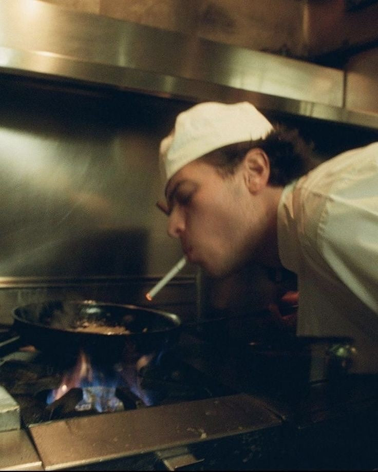 Un cocinero trabajando ante los fogones
