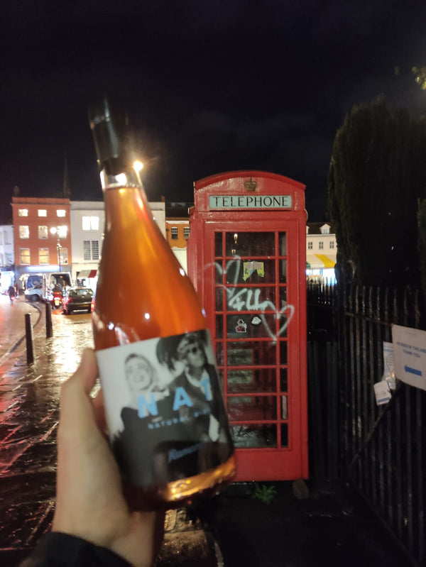 NAT junto a una cabina roja en Londres